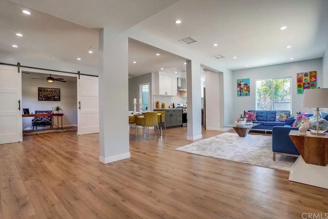 a living room with furniture and a view of kitchen