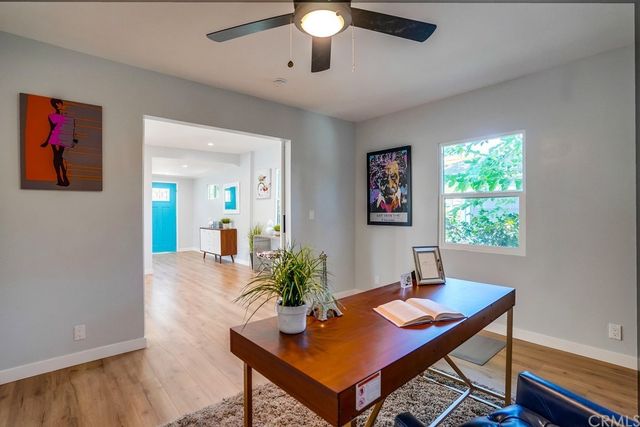 an empty room with painting on the wall and a window