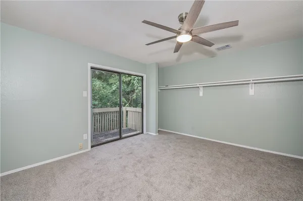 an empty room with fan and windows