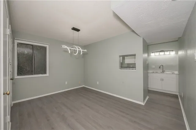 a view of an empty room with closet and a window