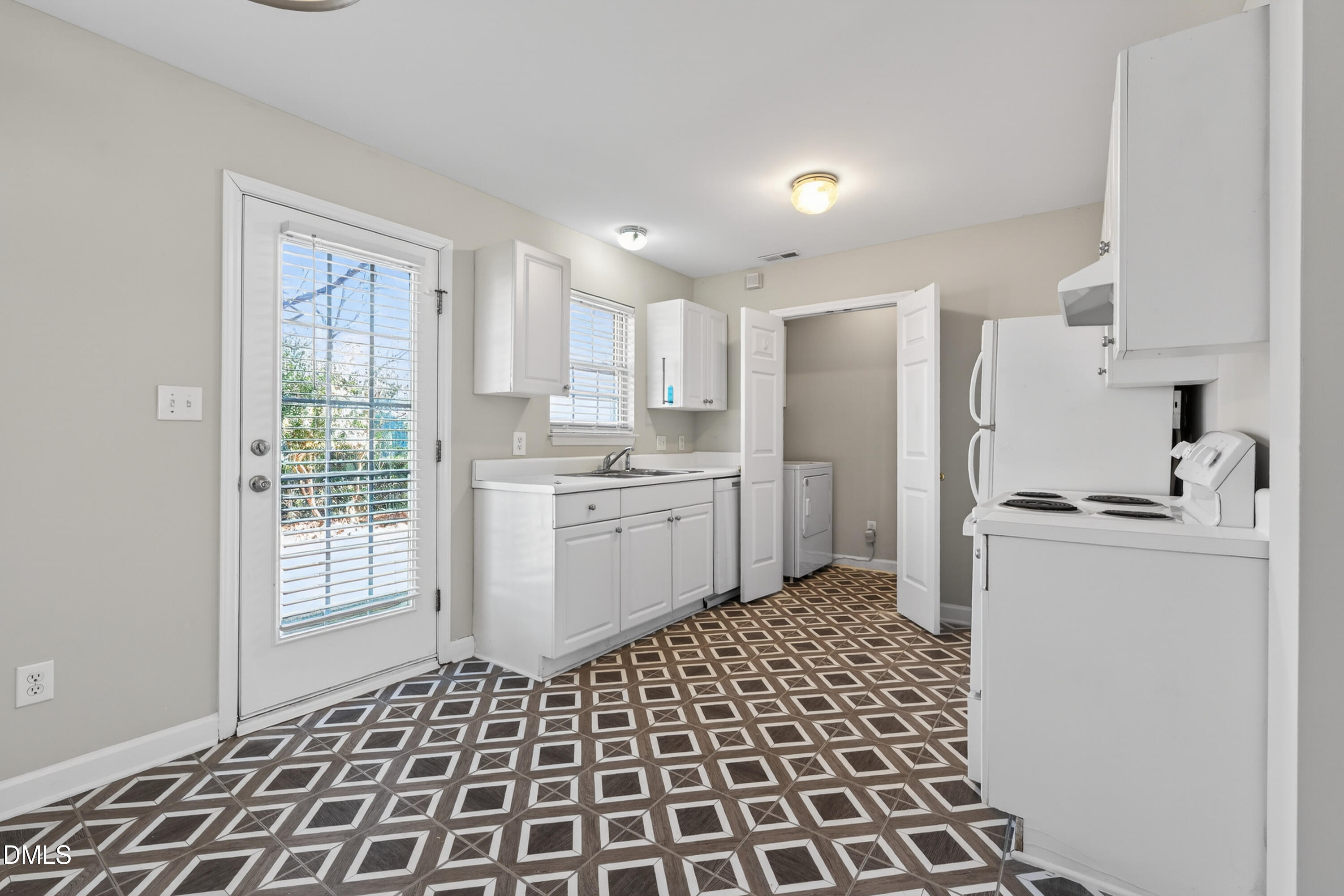 1601 Briarmont Court Raleigh, NC 27610 - Photo 14 of 30 a kitchen with a sink a refrigerator and white cabinets
