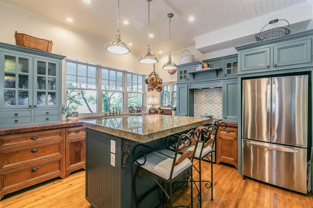 a kitchen with stainless steel appliances granite countertop a refrigerator a sink and a stove