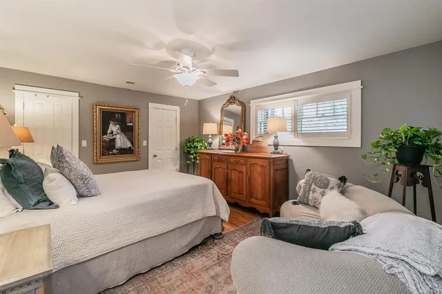 a bedroom with a large bed and windows