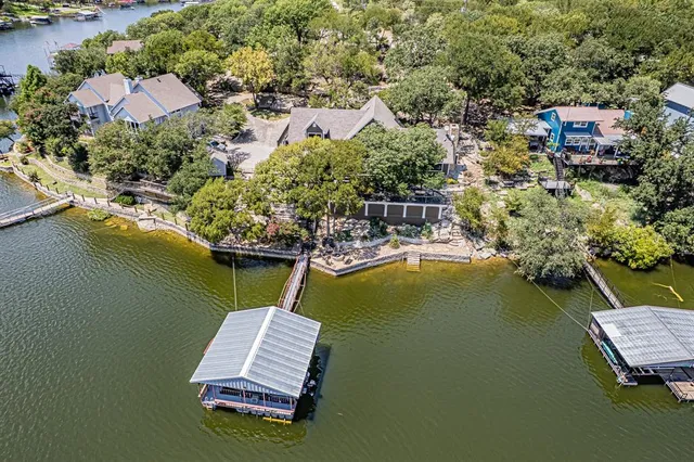 an aerial view of a house with a garden and lake view