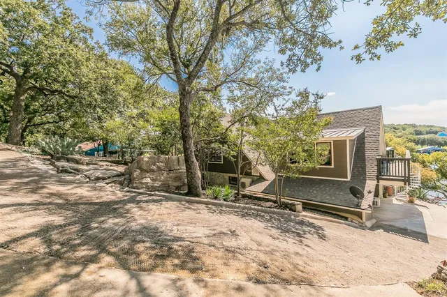 a view of backyard with wooden fence and large trees