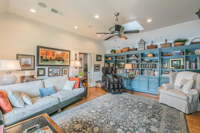 a living room with furniture kitchen view and a wooden floor