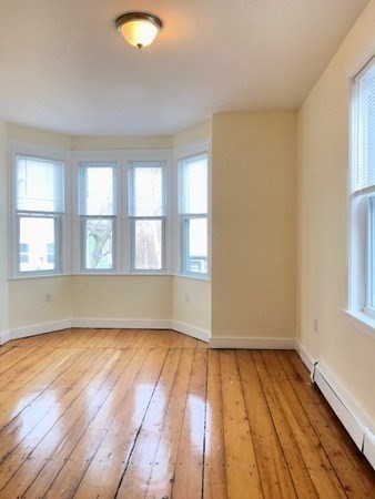 22 Marcella Street, Unit 2 Boston, MA 02119 - Photo 11 of 12 an empty room with wooden floor and windows