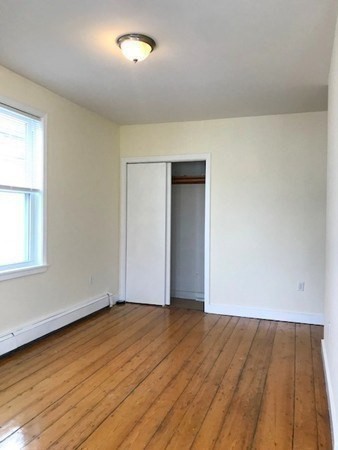 22 Marcella Street, Unit 2 Boston, MA 02119 - Photo 12 of 12 an empty room with wooden floor and windows