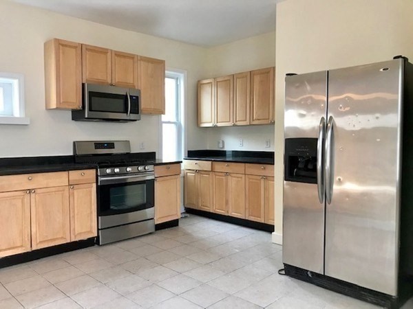 22 Marcella Street, Unit 2 Boston, MA 02119 - Photo 4 of 12 a kitchen with a refrigerator stove and microwave