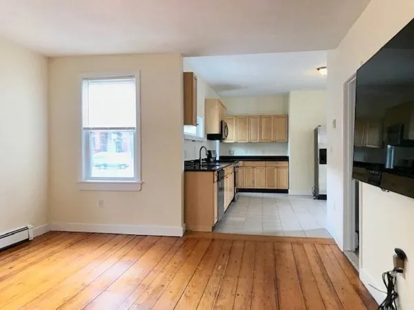 a view of a kitchen with wooden floor and a kitchen