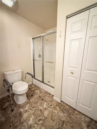 a bathroom with a toilet a sink a shower and a mirror