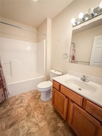 a bathroom with a granite countertop sink toilet a mirror and shower