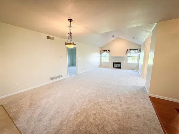 a view of a hallway with a chandelier and fireplace