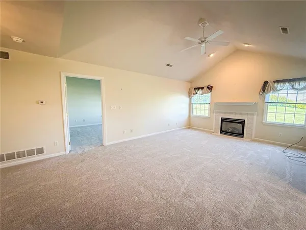 an empty room with windows and fireplace