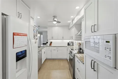 a kitchen with white cabinets and white appliances