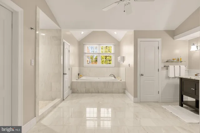 a spacious bathroom with a tub shower and windows