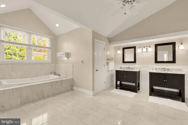 a spacious bathroom with a tub sink shower and mirror