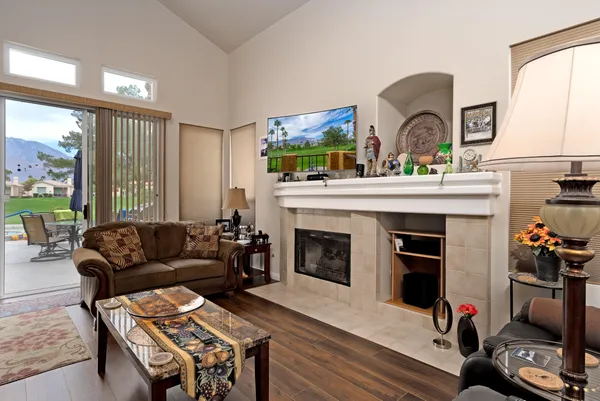 a living room with furniture a fireplace and a large window