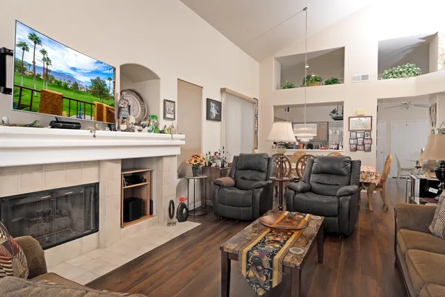 a living room with furniture a fireplace and a flat screen tv