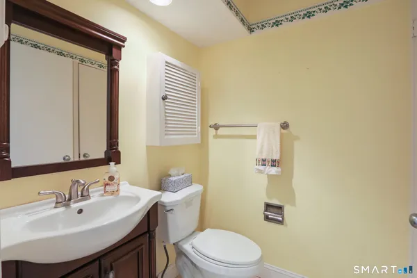 a bathroom with a sink mirror vanity and toilet