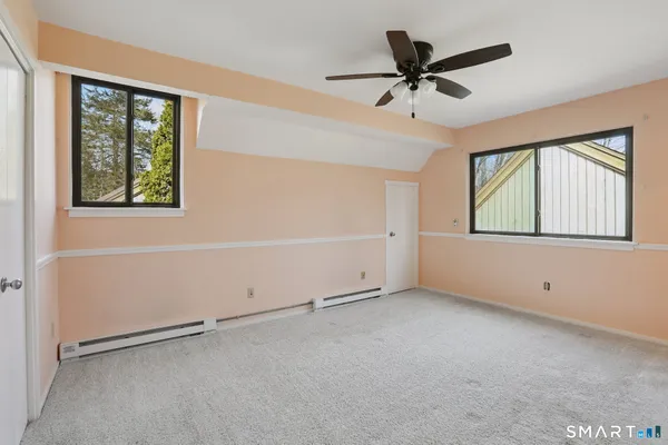 an empty room with windows and ceiling fan