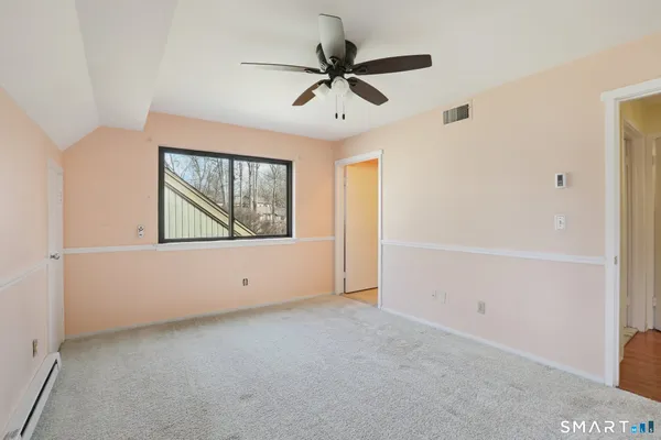 an empty room with fan and windows