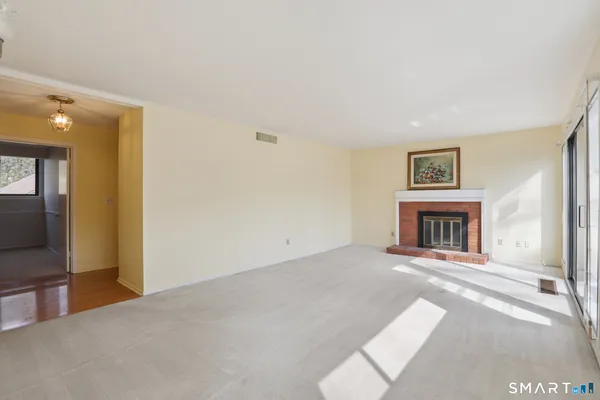 a view of an empty room with a fireplace and a window