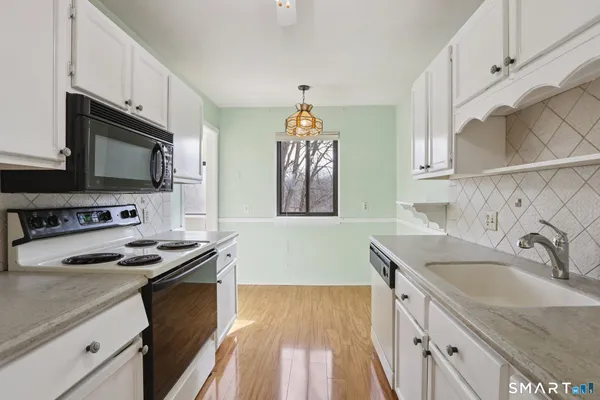 a kitchen with granite countertop a sink stove and microwave