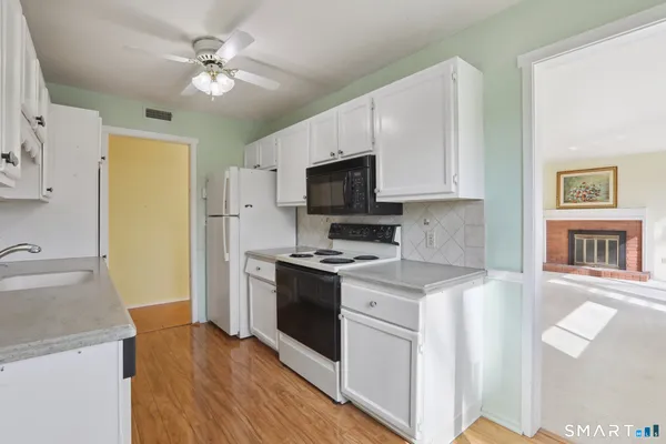 a kitchen with stainless steel appliances granite countertop hardwood floor sink stove and refrigerator