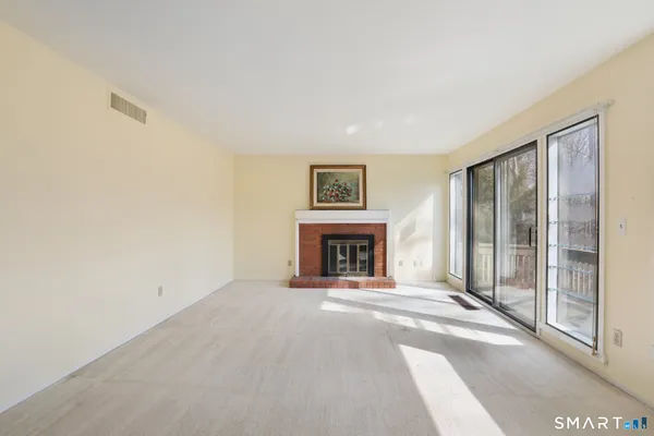 a view of an empty room with a fireplace and a window