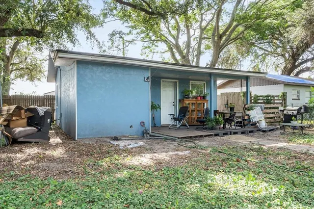 a view of a chair and table in backyard of house