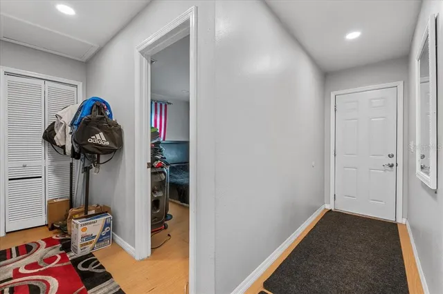 a view of a hallway to room and room with wooden floor