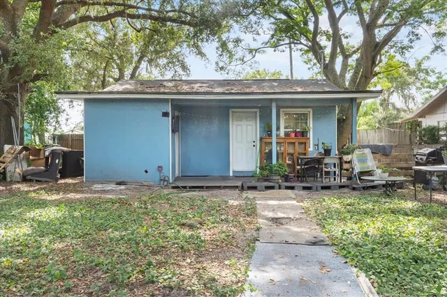 a view of a chair and table in backyard of the house