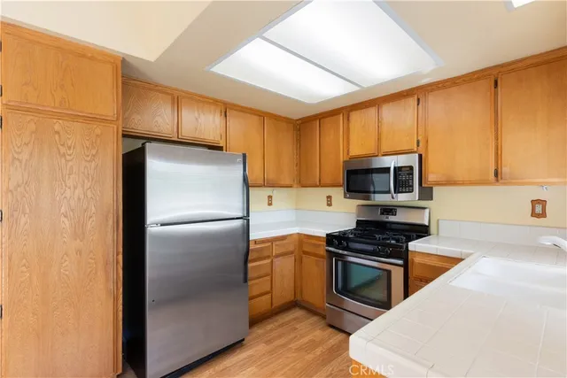 a kitchen with stainless steel appliances a refrigerator a stove a sink a microwave and cabinets