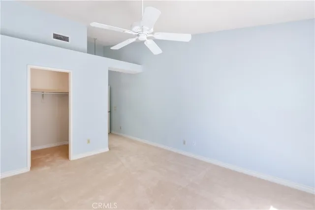 an empty room with a fan & a window