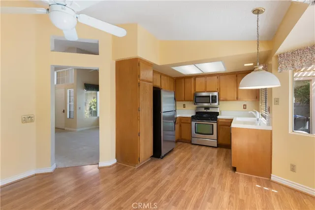 a kitchen with stainless steel appliances a refrigerator a stove a sink dishwasher and a oven with wooden floor