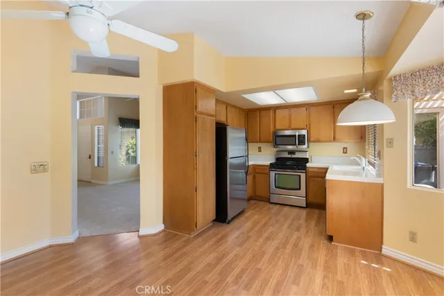 a kitchen with stainless steel appliances a refrigerator a stove a sink dishwasher and a oven with wooden floor