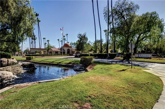 a view of swimming pool with lawn chairs and plants