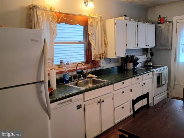 a kitchen with stainless steel appliances granite countertop a sink a stove and a refrigerator