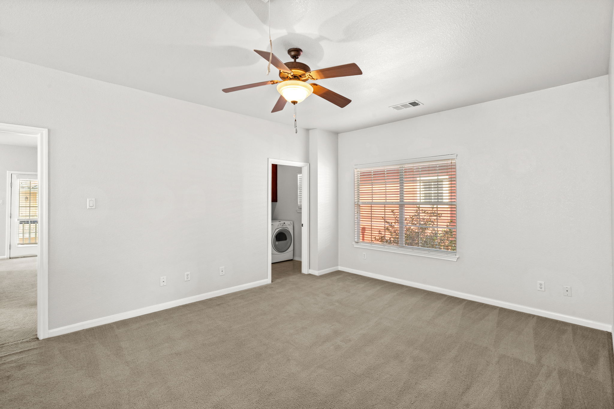 6704 Menchaca Road, Unit 42 Austin, TX 78745 - Photo 9 of 21 A well-lit bedroom provides comfortable living space with carpet flooring and a ceiling fan.