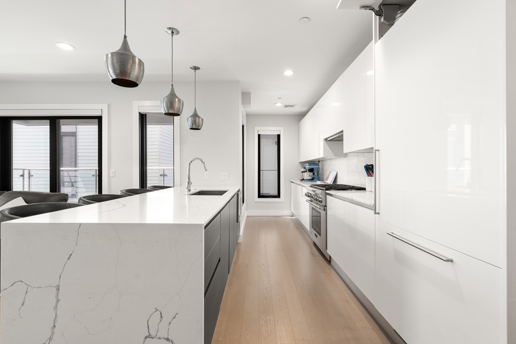 39 A Street, Unit 16 Boston, MA 02127 - Photo 3 of 14 a kitchen with stainless steel appliances kitchen island a refrigerator and a sink