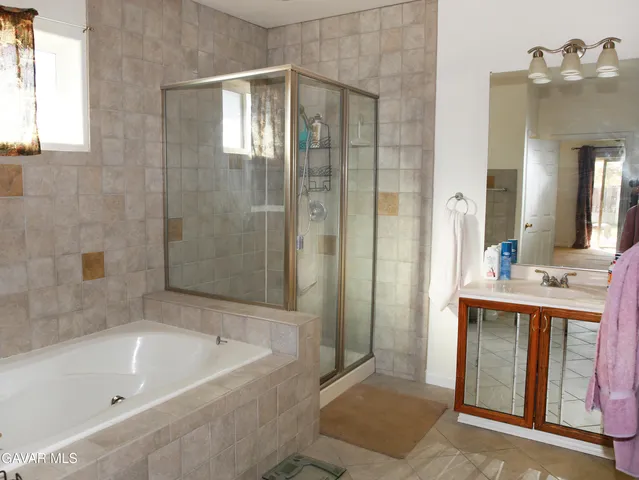 a bathroom with a bathtub sink and mirror