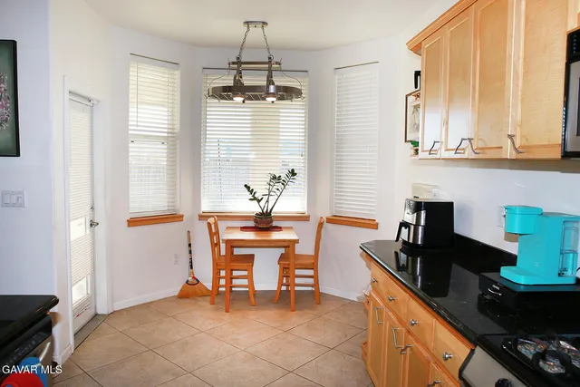 a kitchen with stainless steel appliances a sink stove and table chair