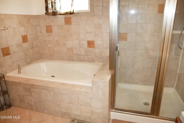 a white bath tub sitting next to a shower