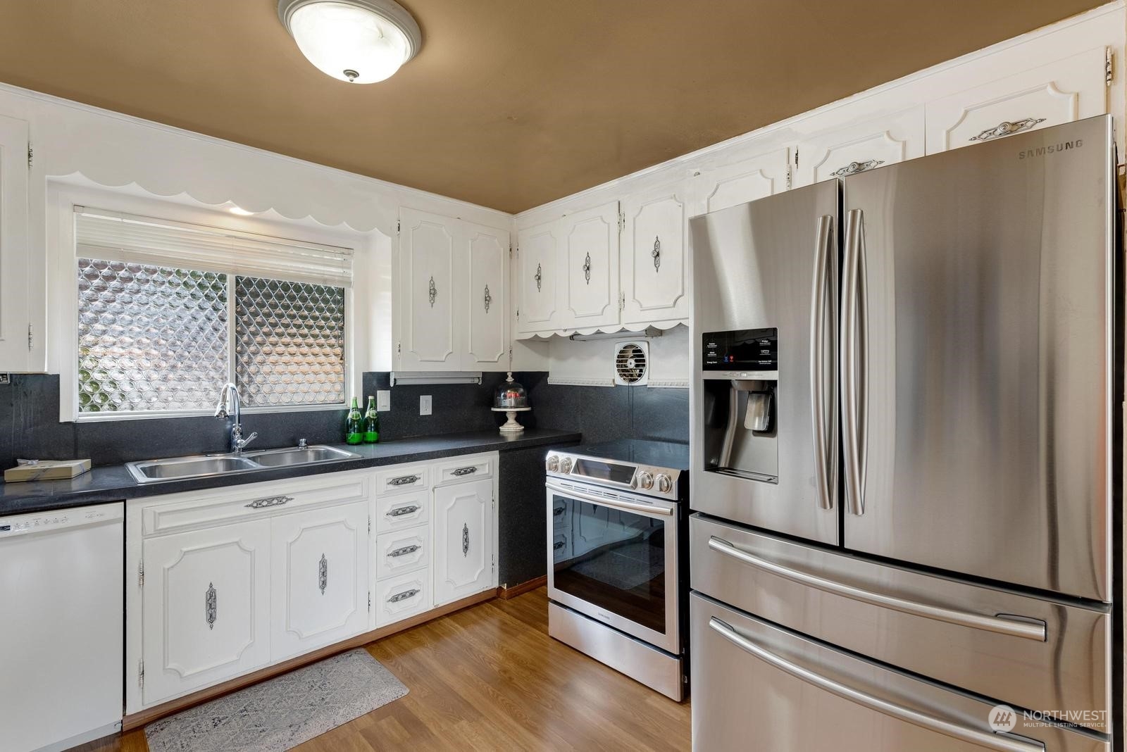 4531 Crescent Avenue Everett, WA 98203 - Photo 2 of 23 a kitchen with granite countertop white cabinets white stainless steel appliances and sink