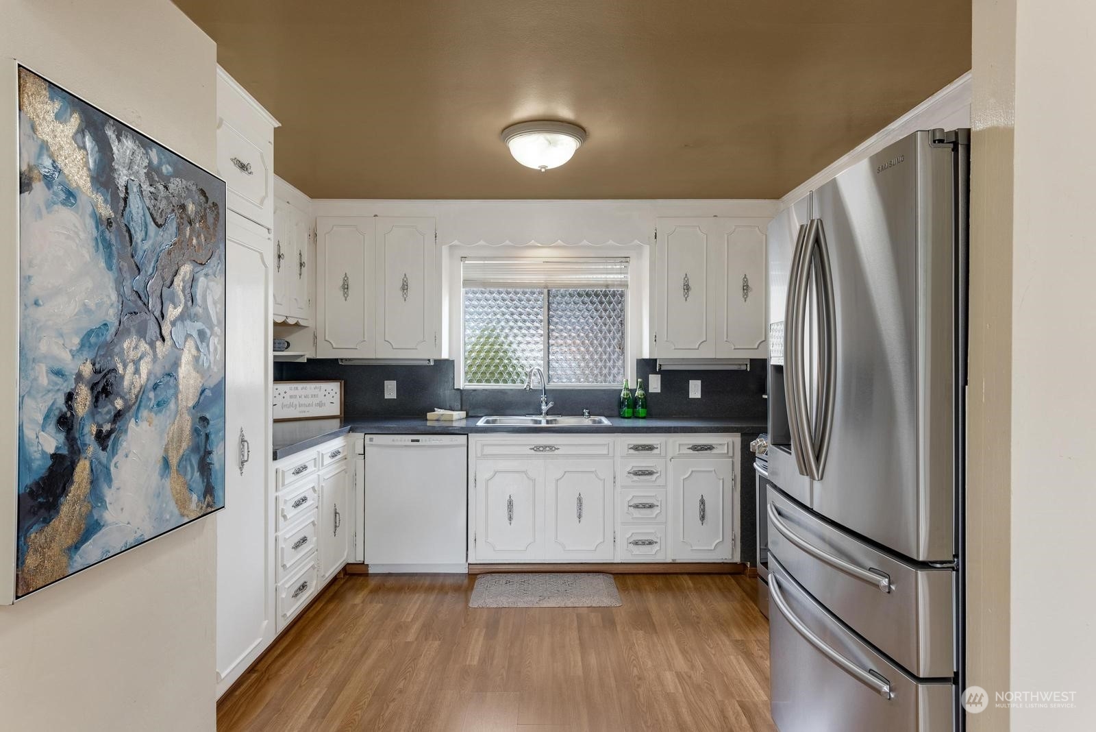 4531 Crescent Avenue Everett, WA 98203 - Photo 4 of 23 a kitchen with stainless steel appliances granite countertop a refrigerator sink and white cabinets