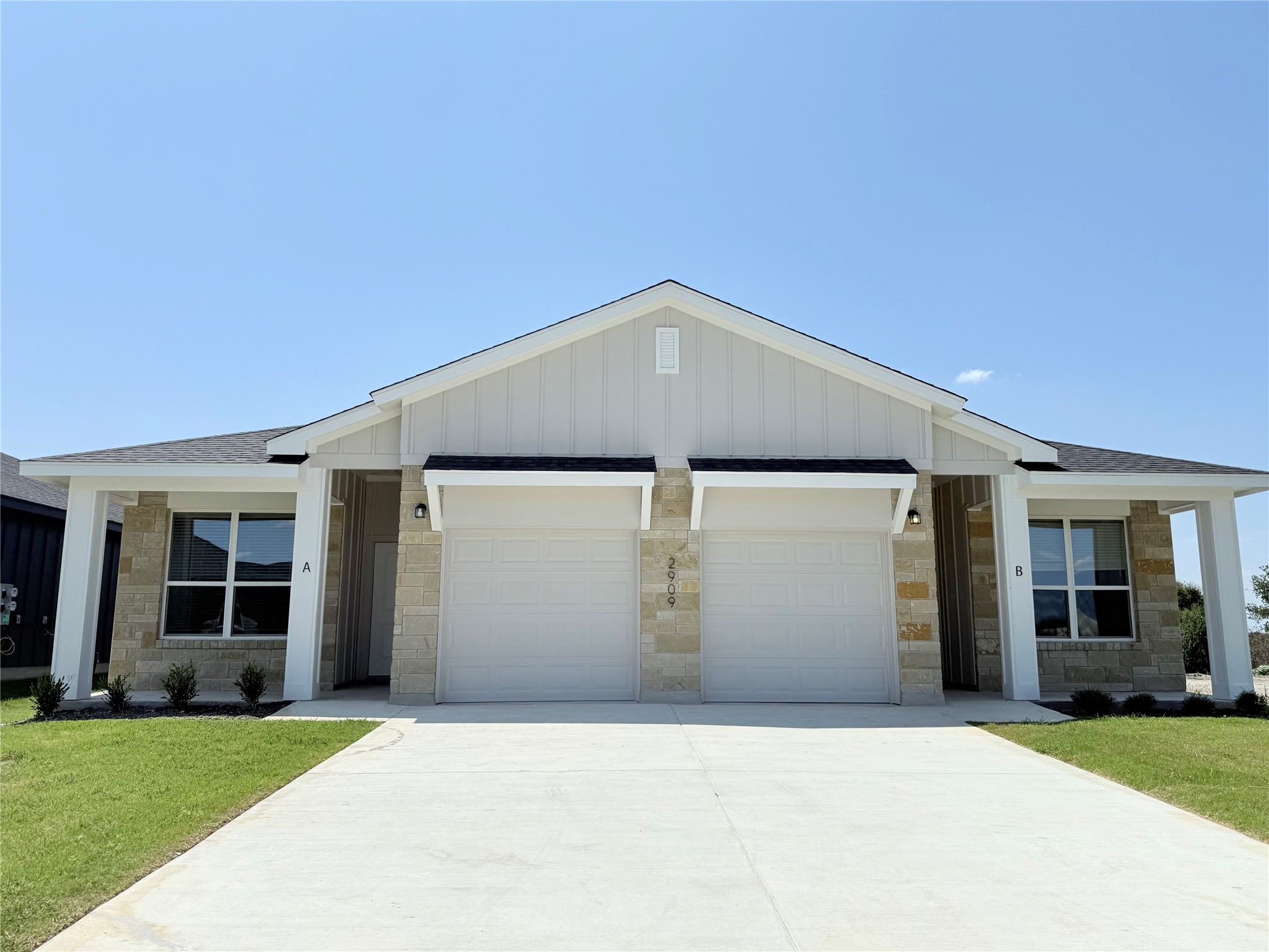 2909 Quail Rdg Lane, Unit A Temple, TX 76501 - Photo 1 of 19 Ranch-style home featuring a garage, concrete driveway, a front lawn, and board and batten siding