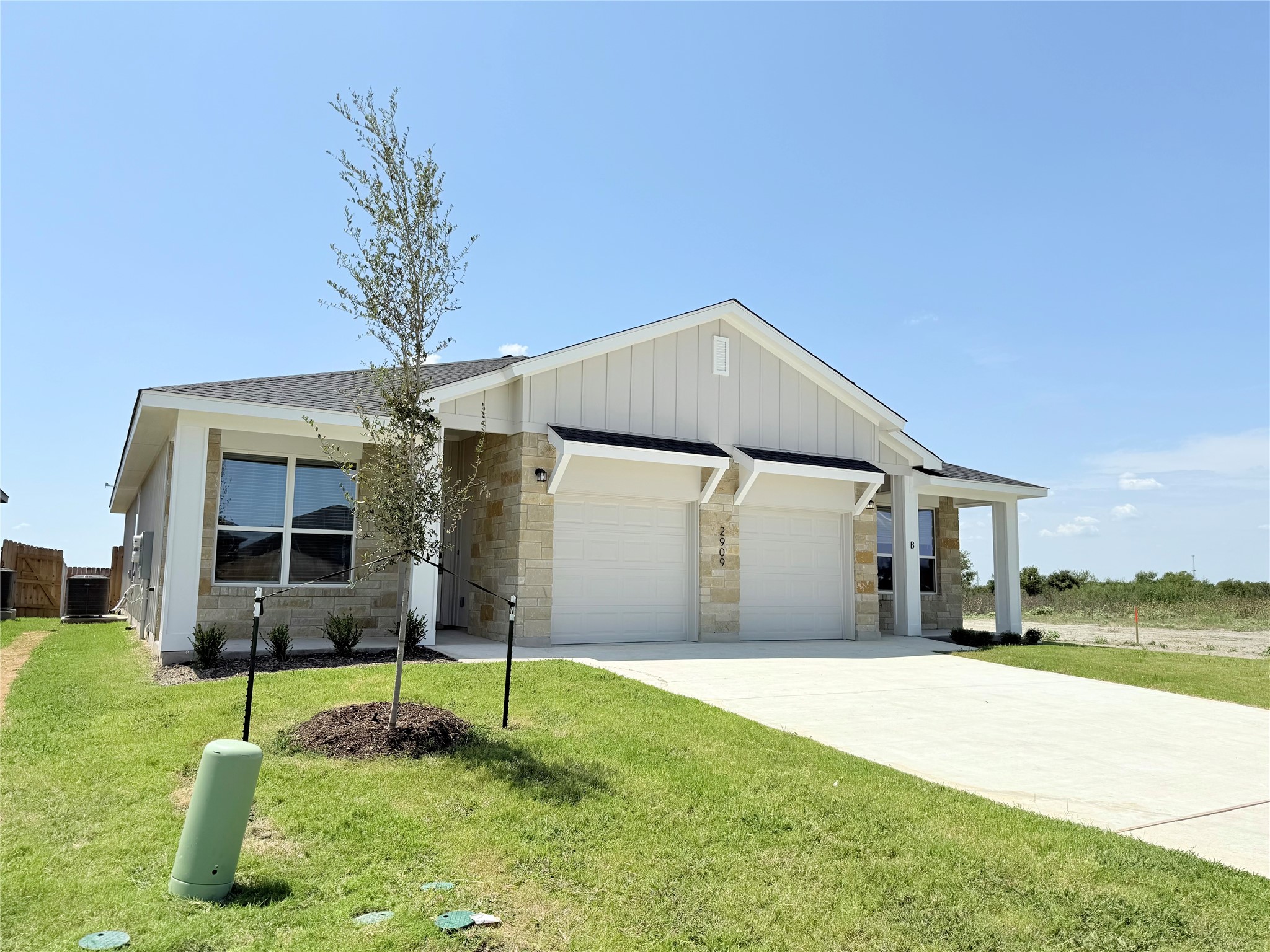 2909 Quail Rdg Lane, Unit A Temple, TX 76501 - Photo 17 of 19 View of front of property featuring a garage, driveway, a front lawn, and board and batten siding