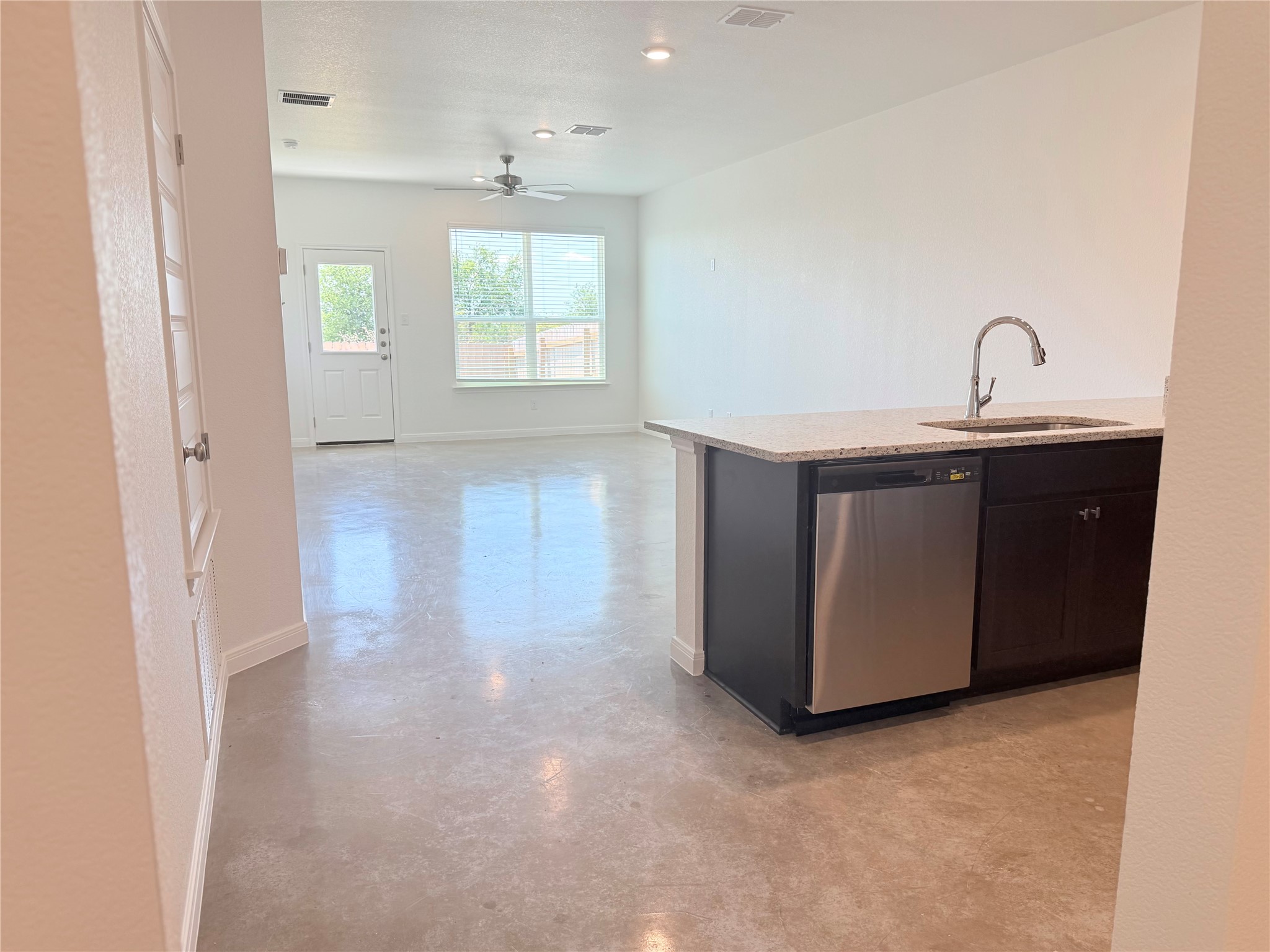 2909 Quail Rdg Lane, Unit A Temple, TX 76501 - Photo 19 of 19 Kitchen featuring finished concrete floors, dishwasher, light stone counters, open floor plan, and ceiling fan