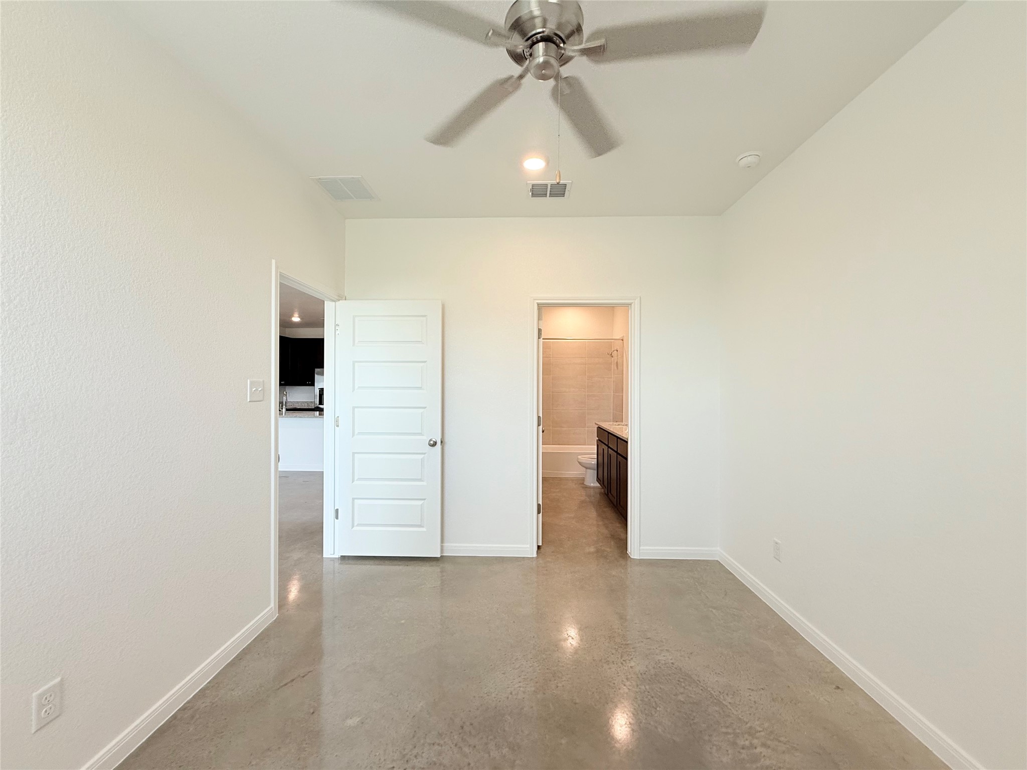 2909 Quail Rdg Lane, Unit A Temple, TX 76501 - Photo 7 of 19 Unfurnished bedroom featuring finished concrete flooring, ceiling fan, and ensuite bathroom